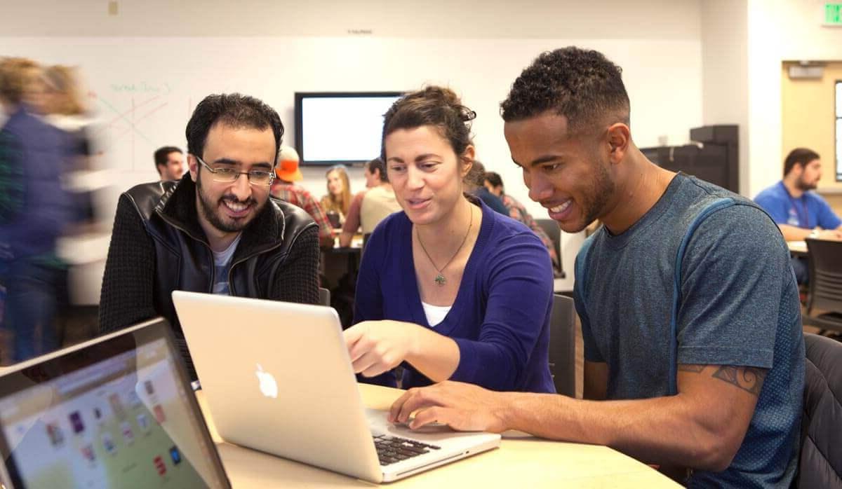 Students and professor looking at laptop